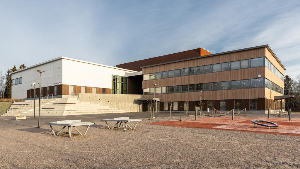 Hämeenkylän koulun pääjulkisivu ja rakennuksen edessä piha.