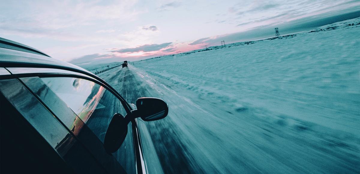 car driving on lonely road during winter