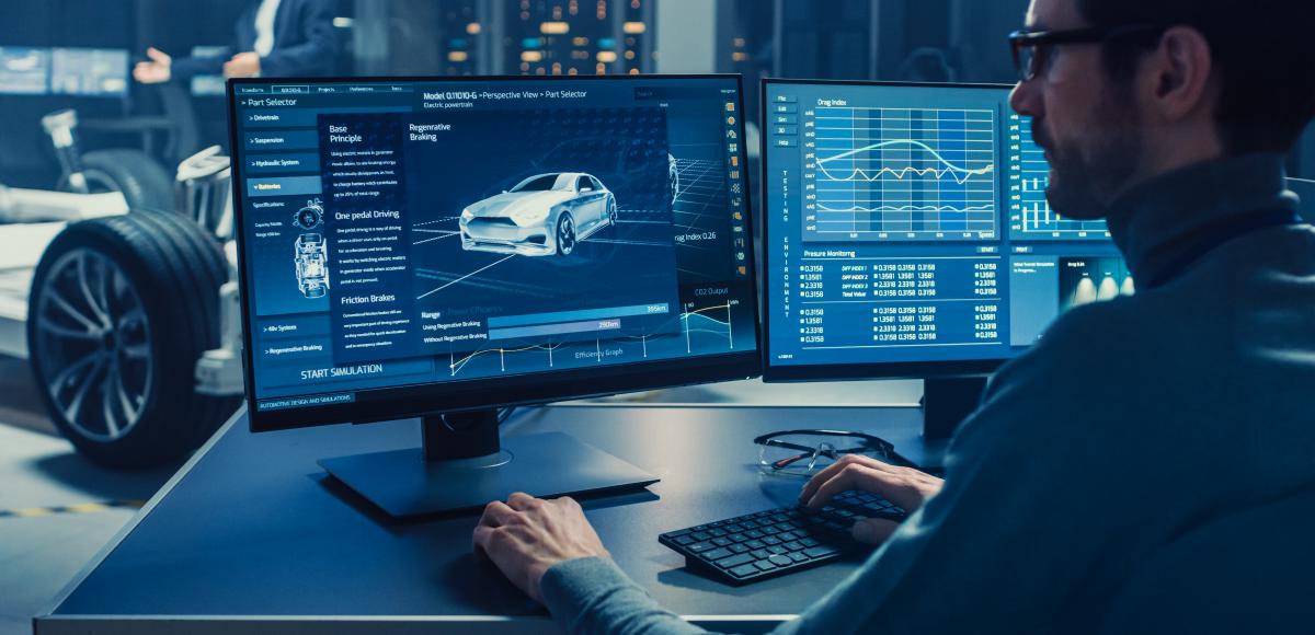 Man looking at computer screen displaying a modern car