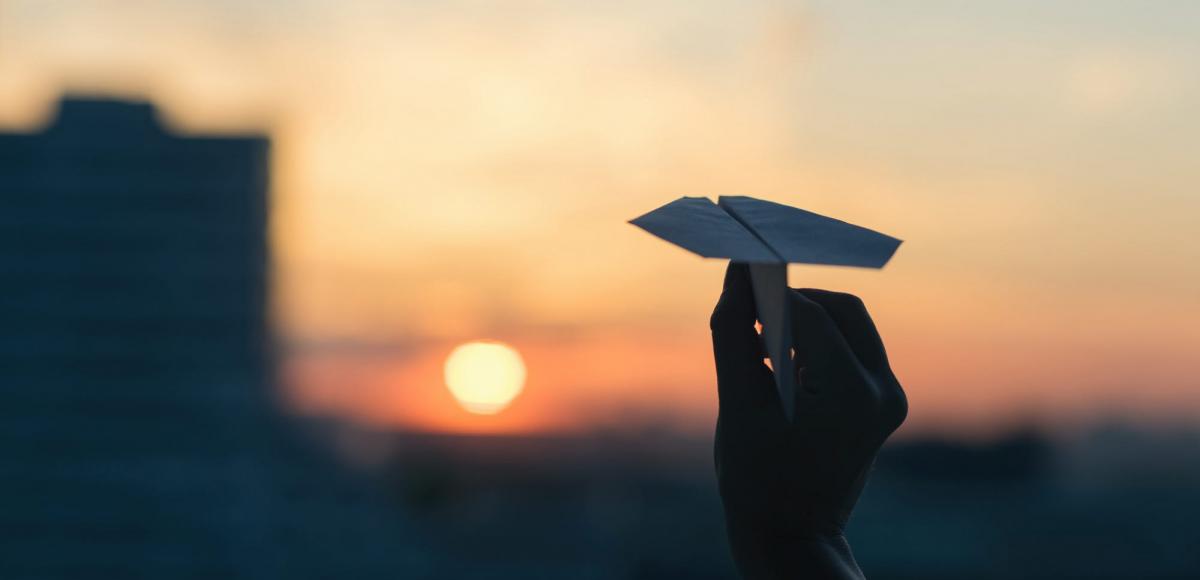 Papierflieger im Sonnenuntergang