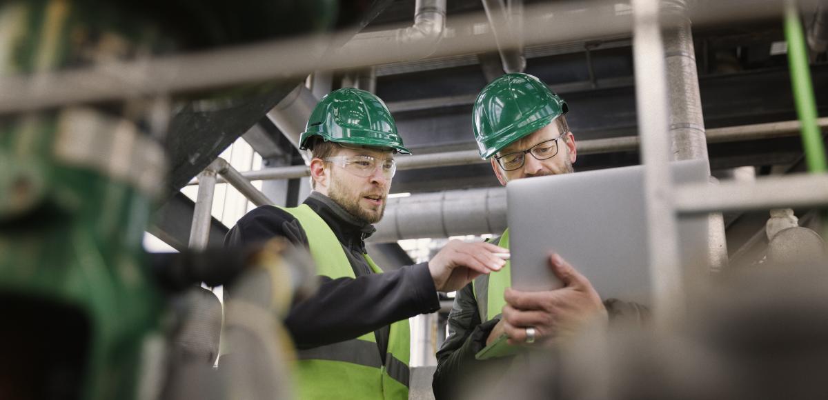 Two guys in a factory working with a tablet