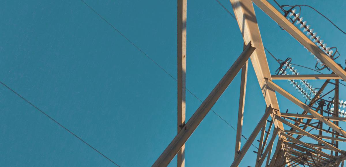 electricity pylon photographed from beneath against blue sky