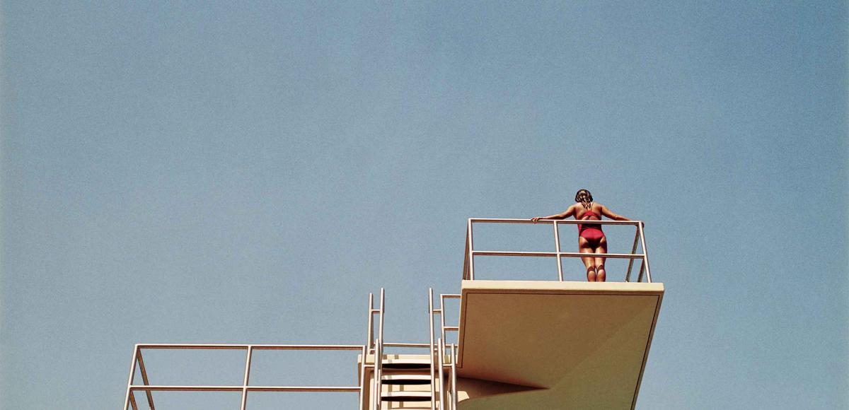 Person contemplating to jump from the swimming tower