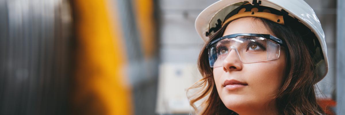 Young businesswoman white helmet googles industrial environment