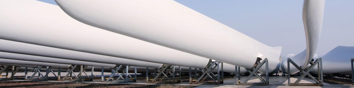 A row of wind turbine blades lying in rigs ready for installation