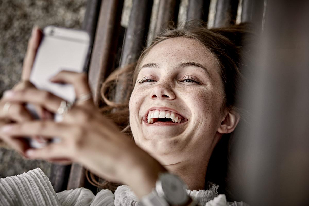 Young person with phone laughing