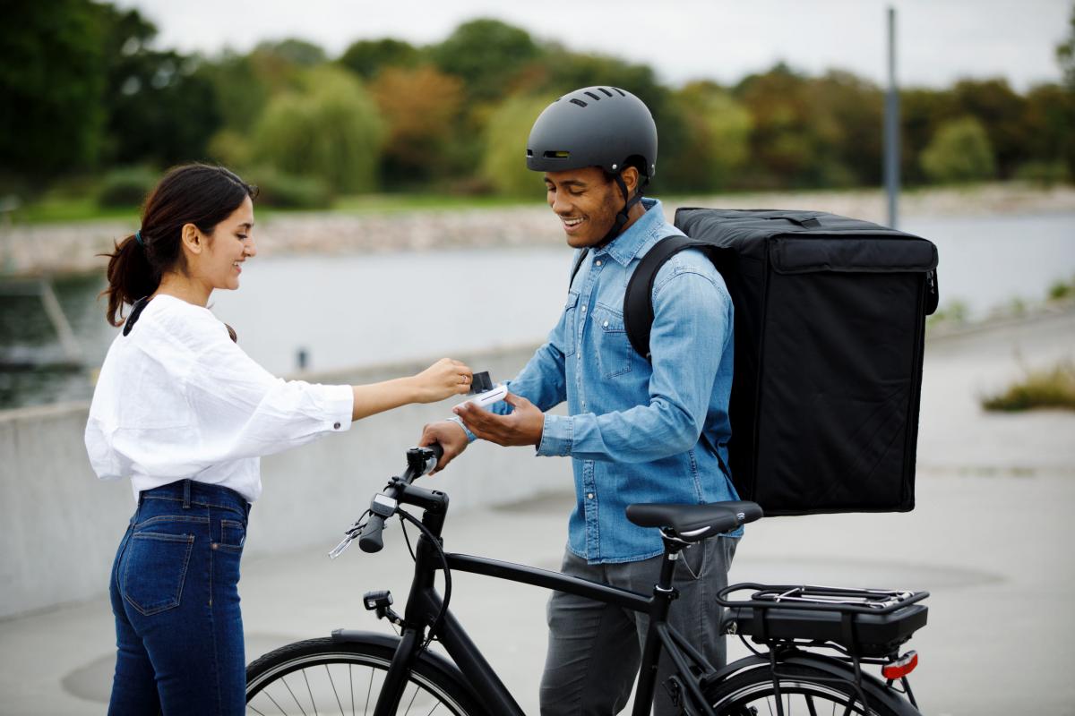 woman in white skirt and man on bicycle talking