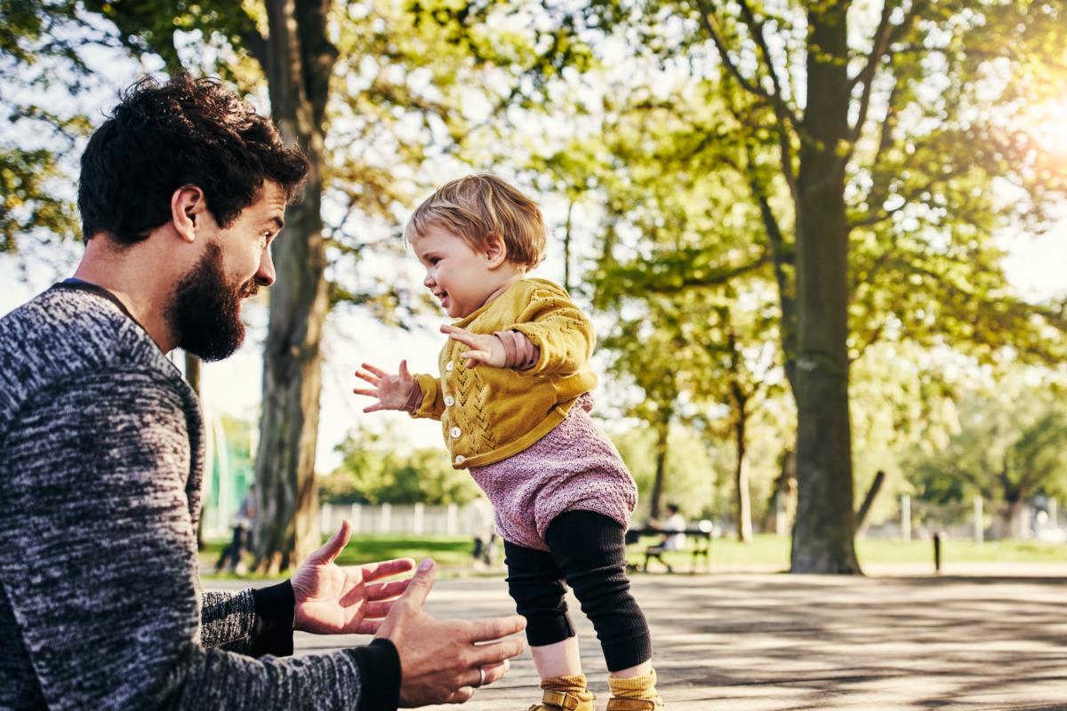 a child is playing in a park with his father