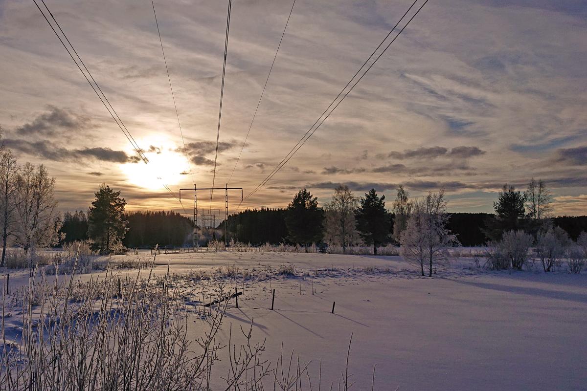 Transmission line in northern winter with low background sun