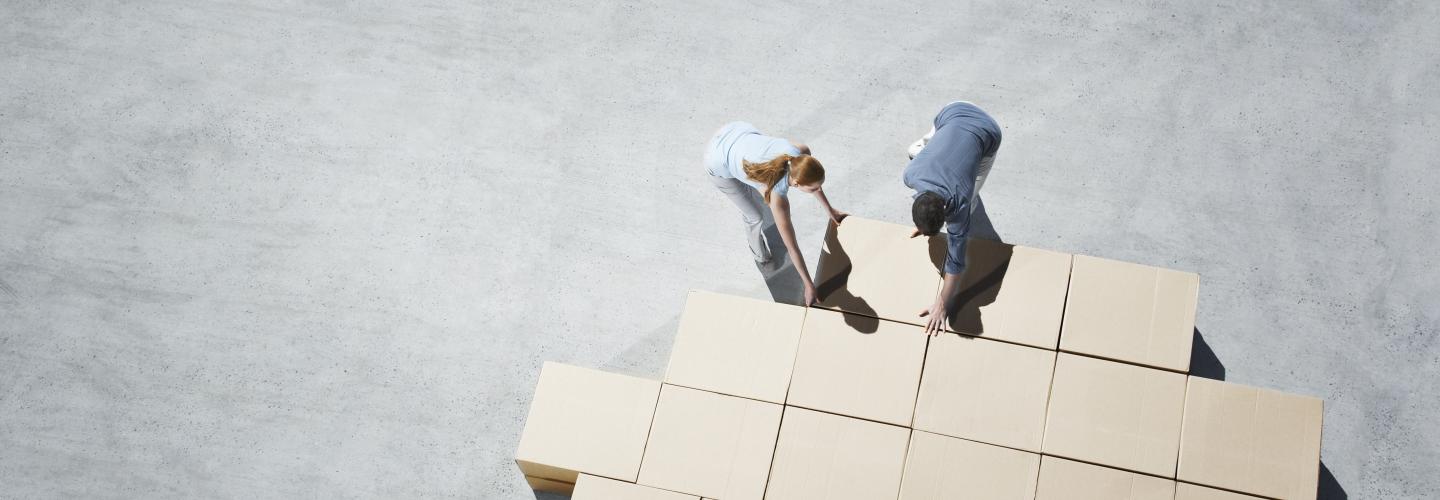 two people organize cardboard boxes logistics packaging