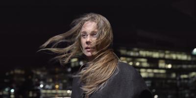 Blonde woman with hair blowing in the wind at night