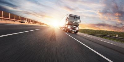 Heavy goods lorry driving along a sunlit road