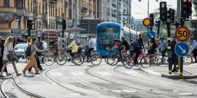 Many cyclists crossing tramway in city