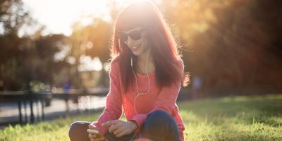 Woman sitting in park on smart phone