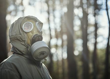 person wearing a gas mask in a forest