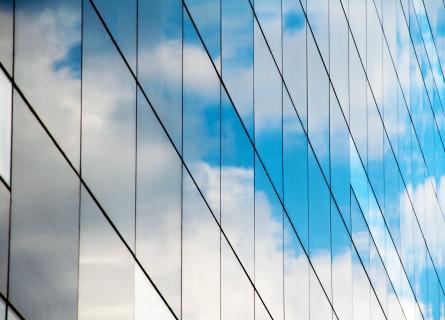 Reflection of blue cloudy sky in glass building