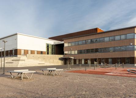 Hämeenkylän koulun pääjulkisivu ja rakennuksen edessä piha.