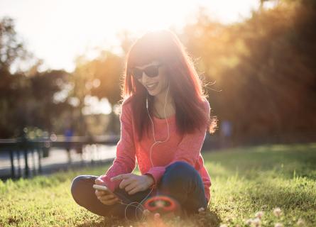 Woman sitting in park on smart phone