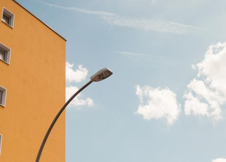 the facade of a yellow house and a street lamp on the left side
