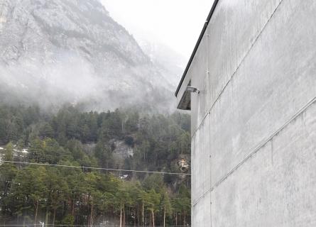 a concrete wall and in the background you can see forest and mountains