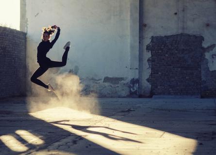 Dancer jumping inside an old industrial building.