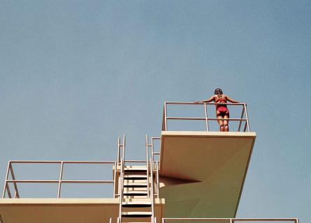 Person contemplating to jump from the swimming tower