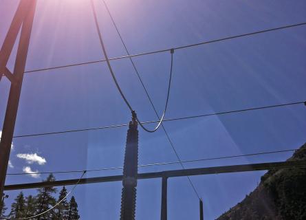 Sun shining down on a detailed view of a substation connection