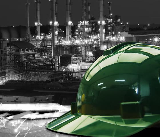 Hard hat on working table in oil refinery plant heavy petrochemical industry estate use for energy,power,fuel,gas and fossil petroleum topic