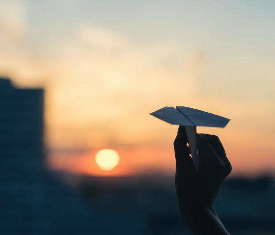 Papierflieger im Sonnenuntergang