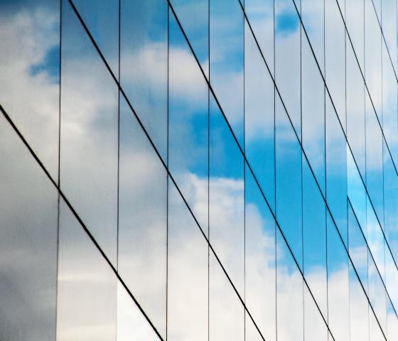Glass building reflecting blue sky