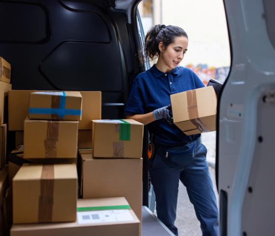 Woman unloading parcels from truck
