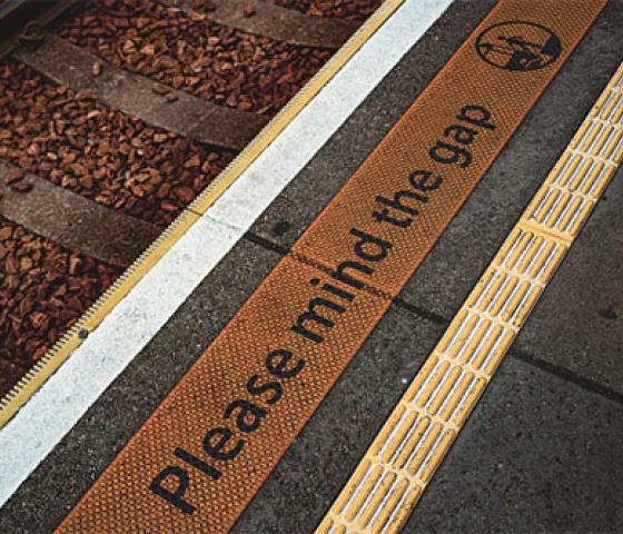 Rail tracks and platform with warning - Please mind the gap