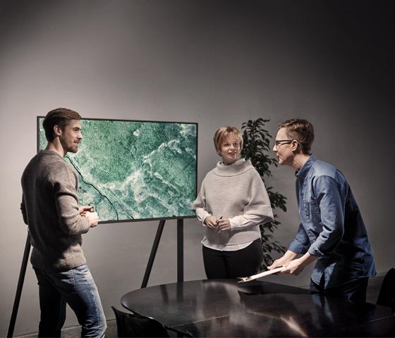 Three people discussing in front of a screen of a forest estate