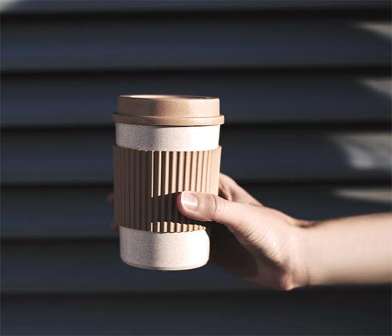 Hand holding a sustainable takeaway carton coffee cup