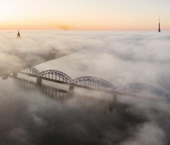 City scape in fog showing river and bridge in sun