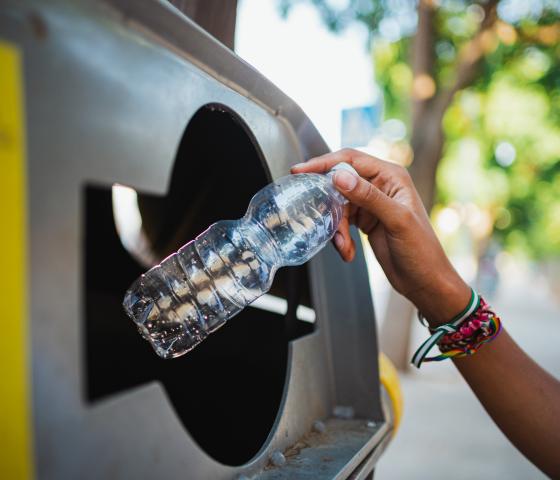 A person recycling a plastic bottle