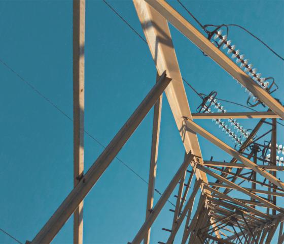 electricity pylon photographed from beneath against blue sky