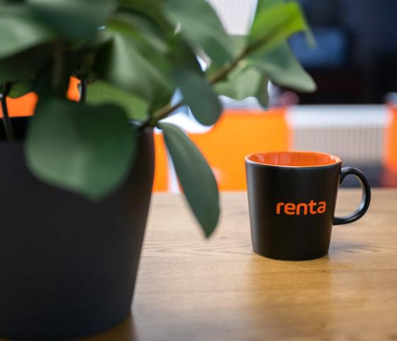 A plant and a coffee cup with Renta's name on it.