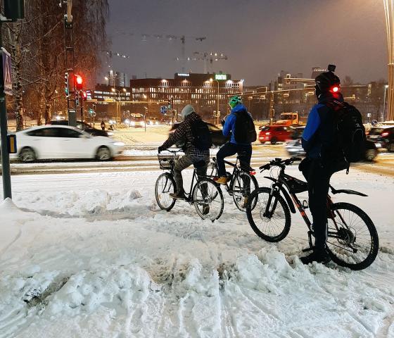 Ihmiset pyöräilevät talvella